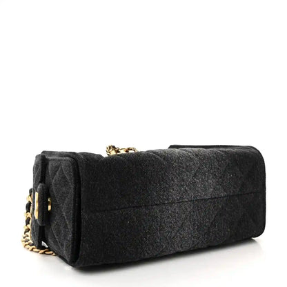 Black mini handbag with quilted texture, gold chain strap, structured top flap