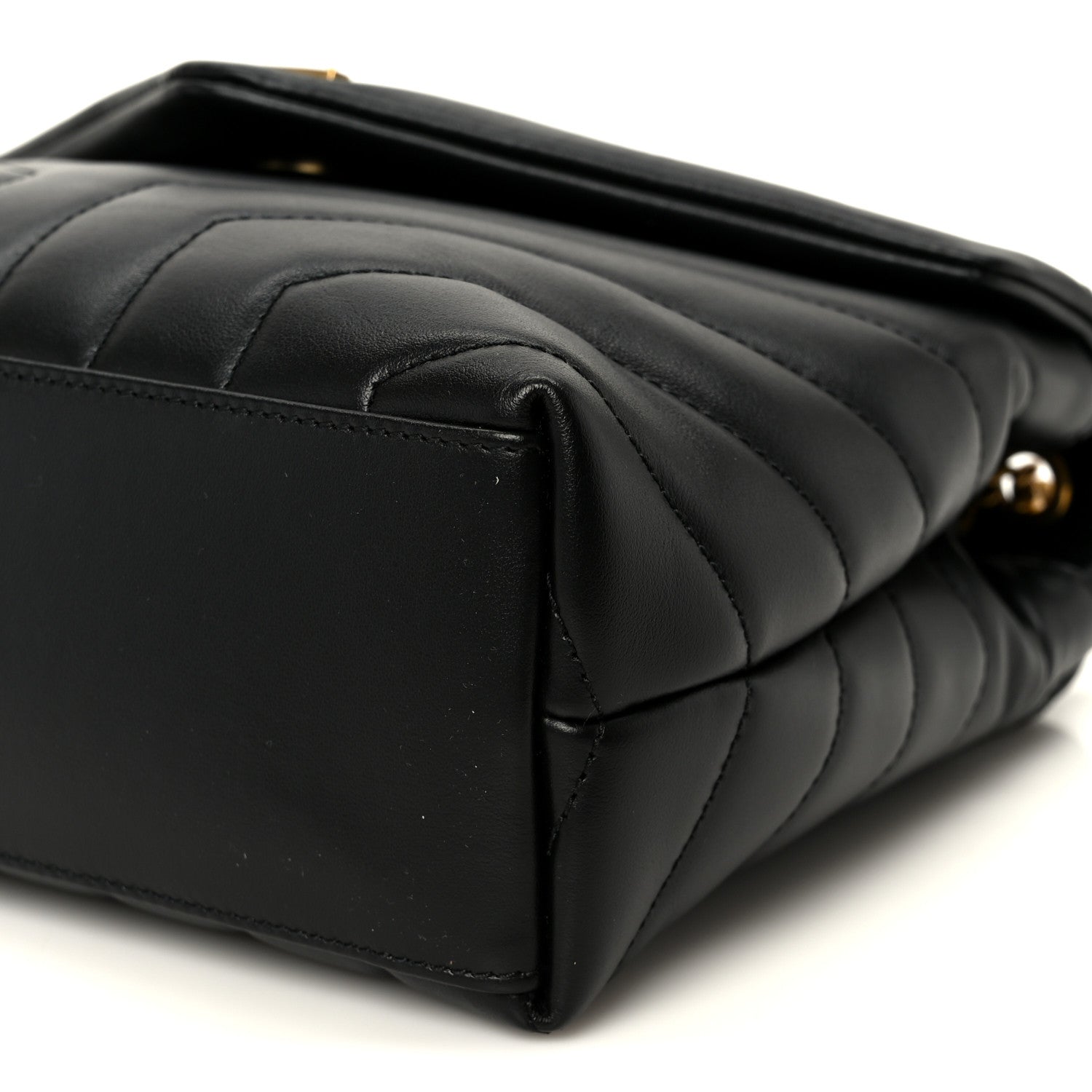 Black quilted leather satchel end with curved seam lines and top edge detail.