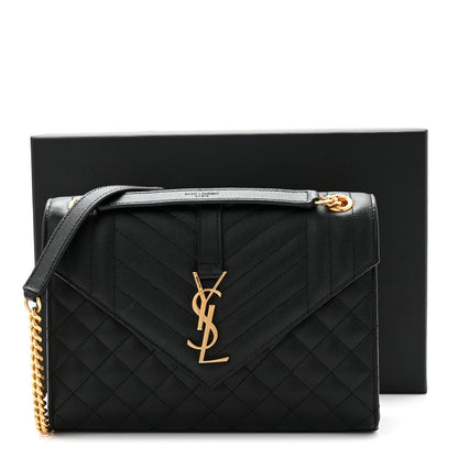 Black quilted satchel bag with gold YSL monogram, shoulder chain, and top flap