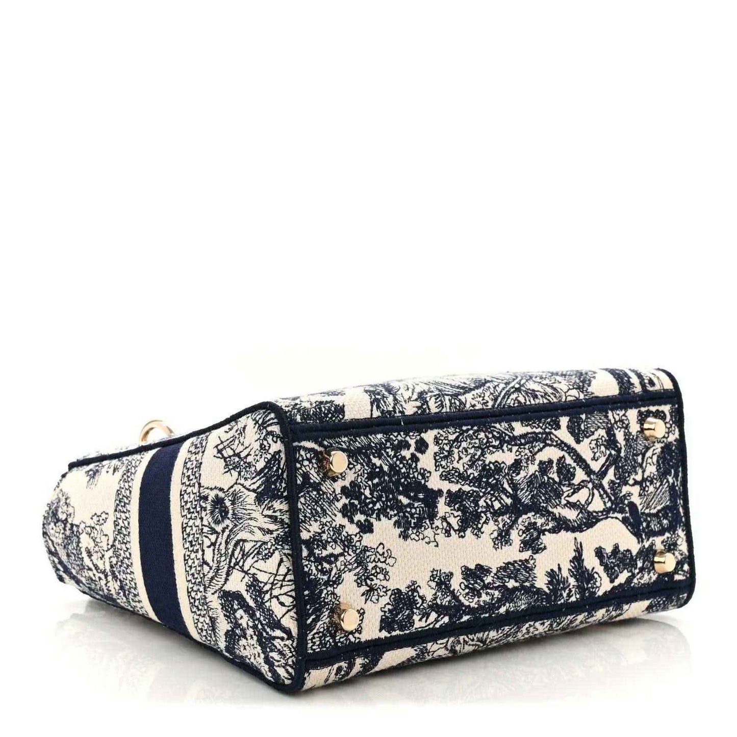 Blue toile de Jouy embroidered handbag side view with zip top and gold corner hardware.