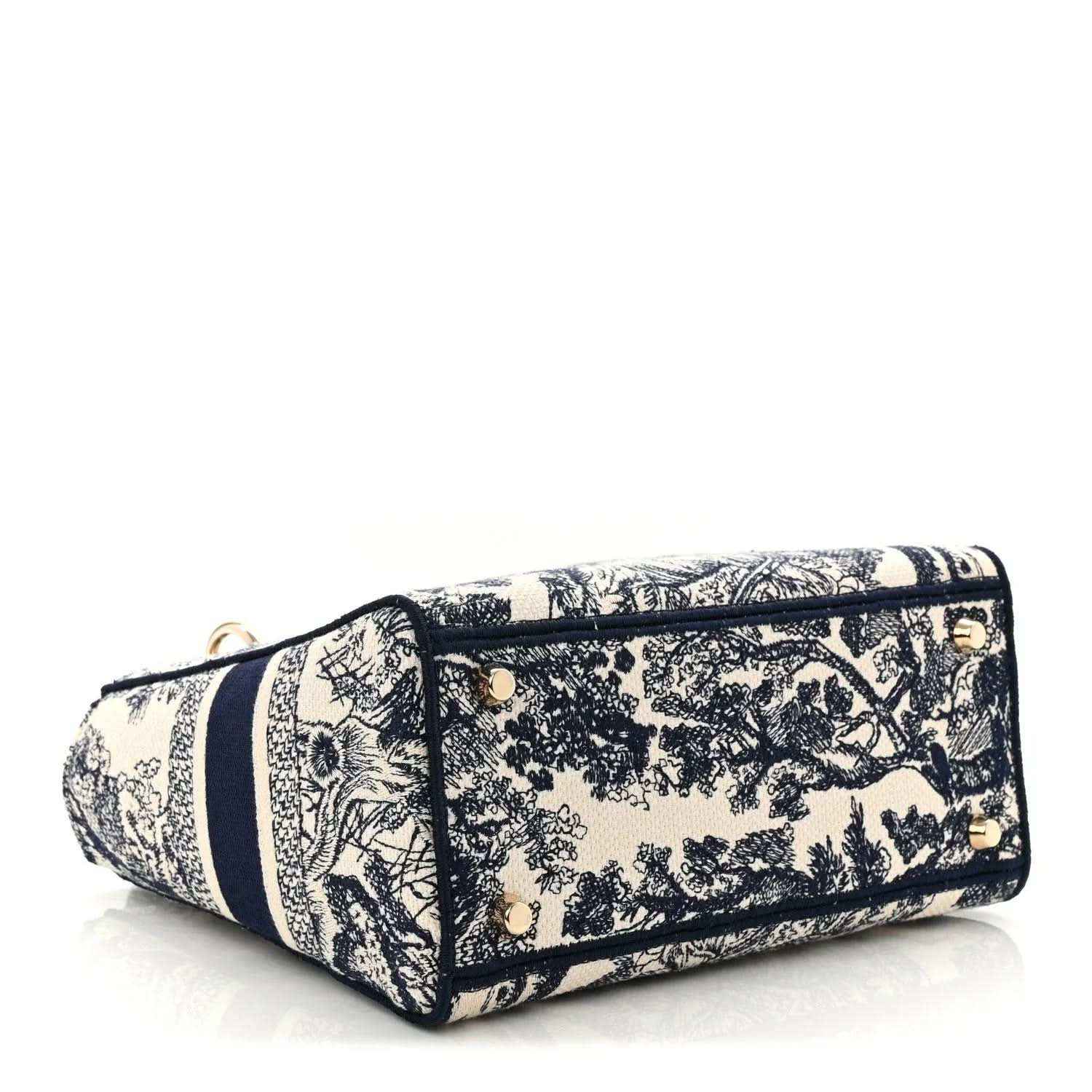 Blue toile de Jouy embroidered handbag side view with zip top and gold corner hardware.