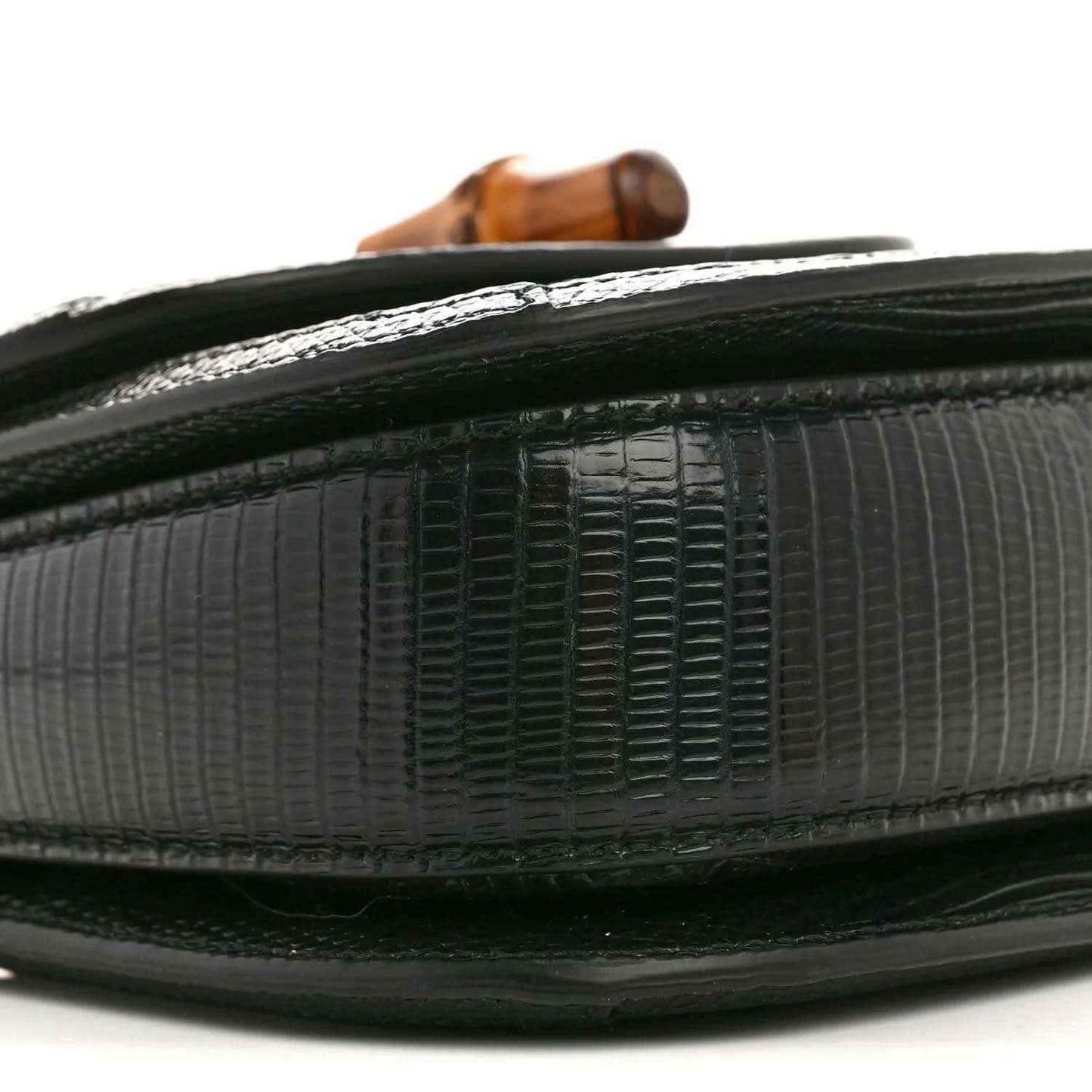 Gucci mini top handle bag edge close-up, black embossed lizard texture with trim