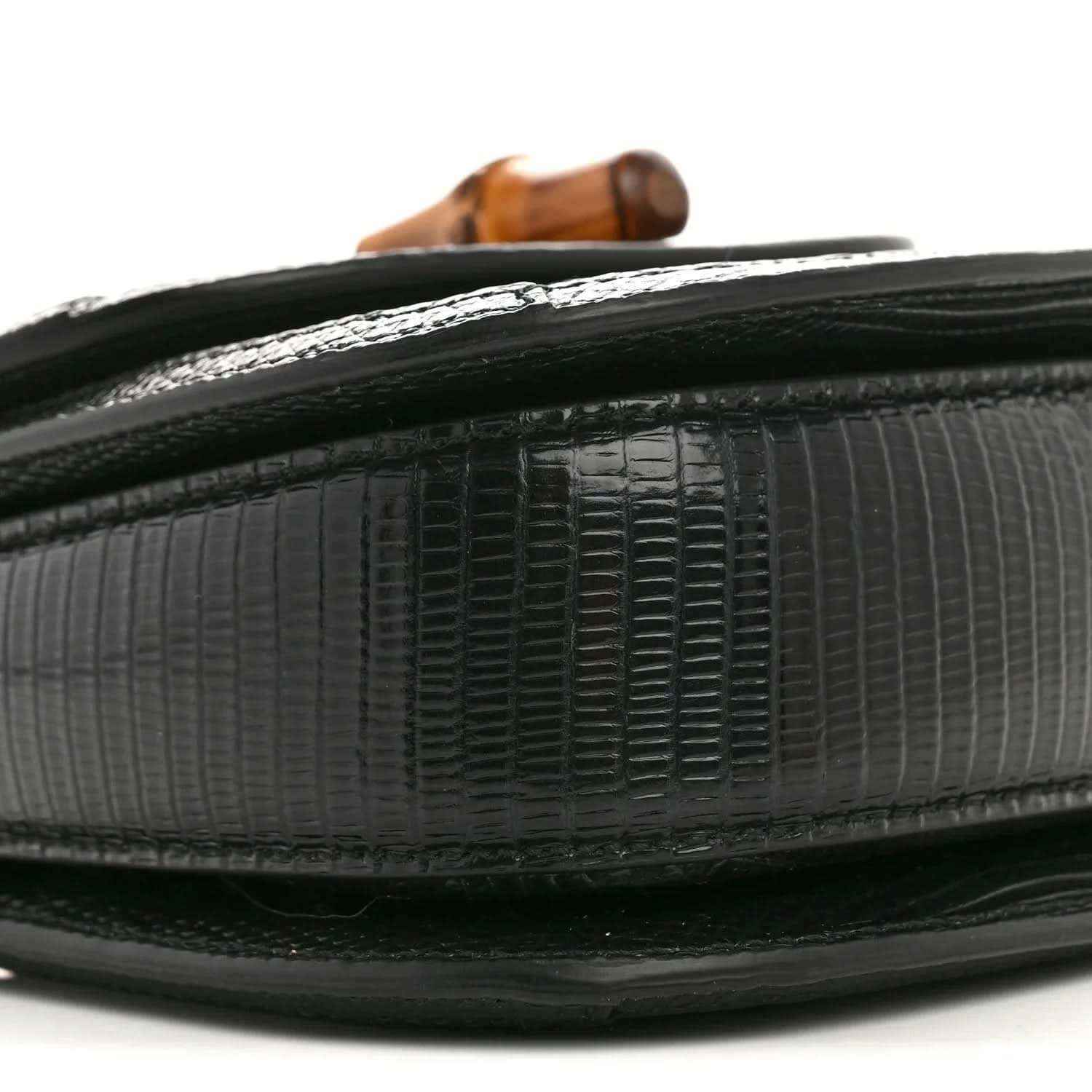 Gucci mini top handle bag edge close-up, black embossed lizard texture with trim