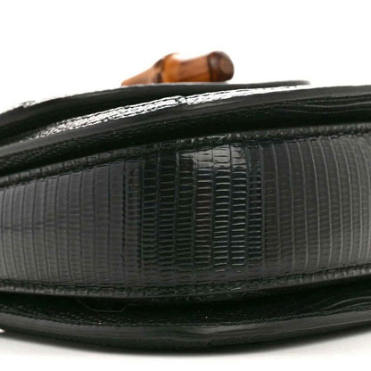 Gucci mini top handle bag edge close-up, black embossed lizard texture with trim