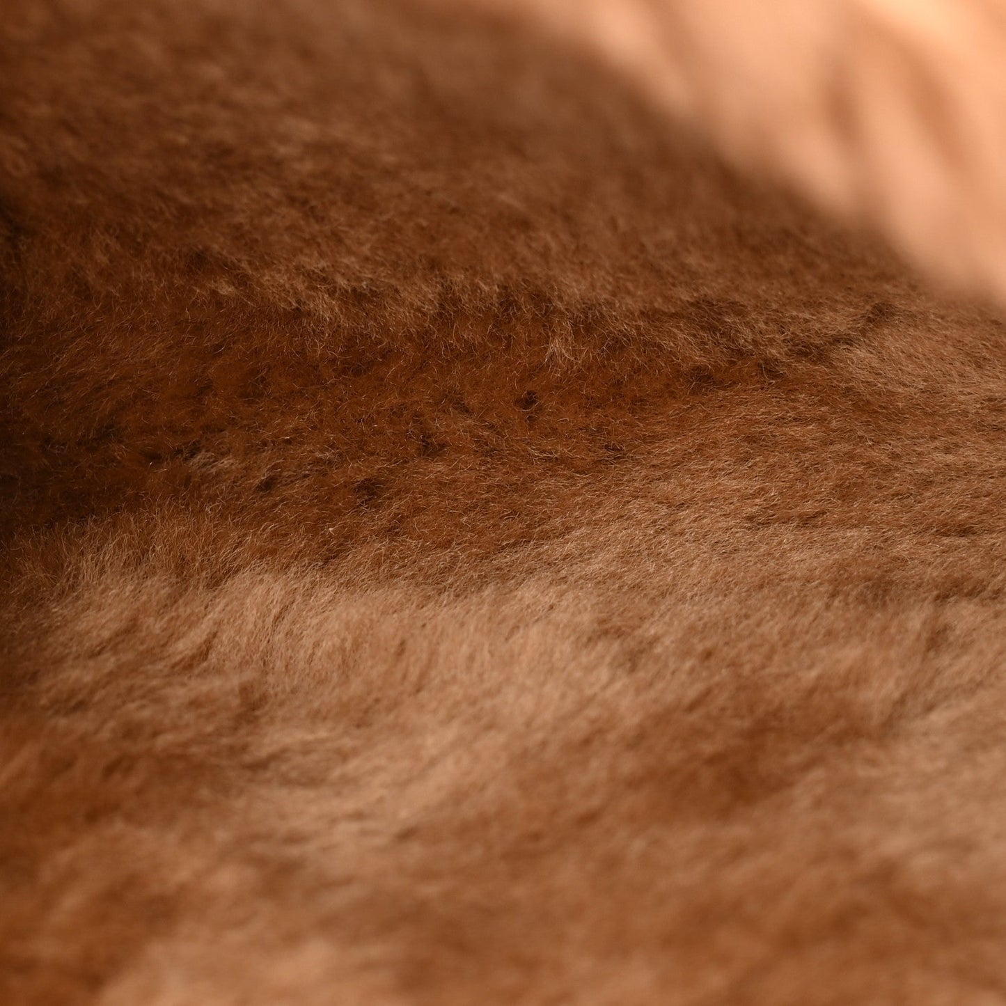 Ecru shearling fur closeup on a small reversible satchel