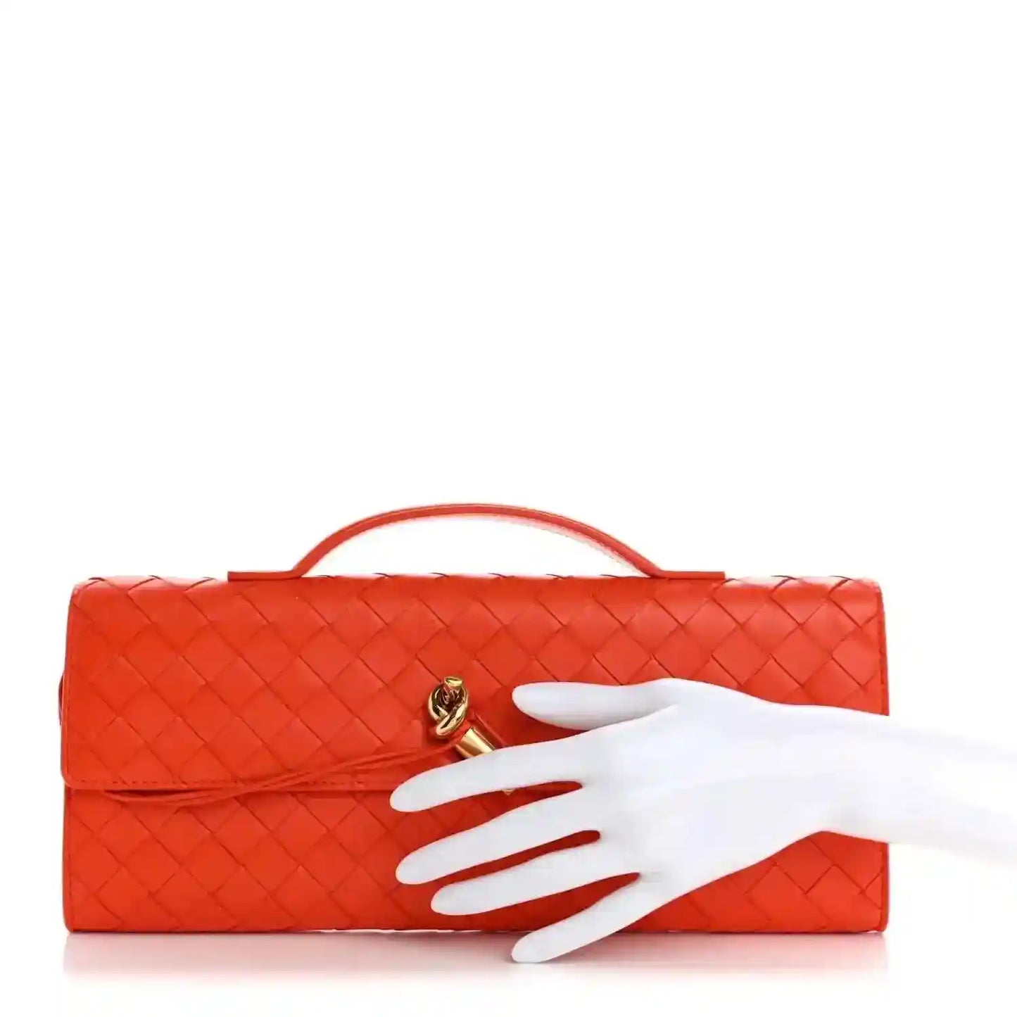 Orange intrecciato nappa top handle clutch with gold-tone clasp; hand shown for scale