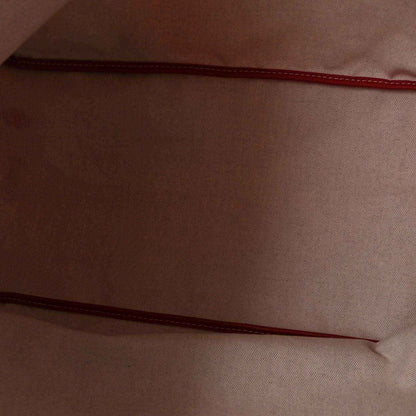 Red fabric lining with stitched seam inside a Goyardine canvas tote bag.