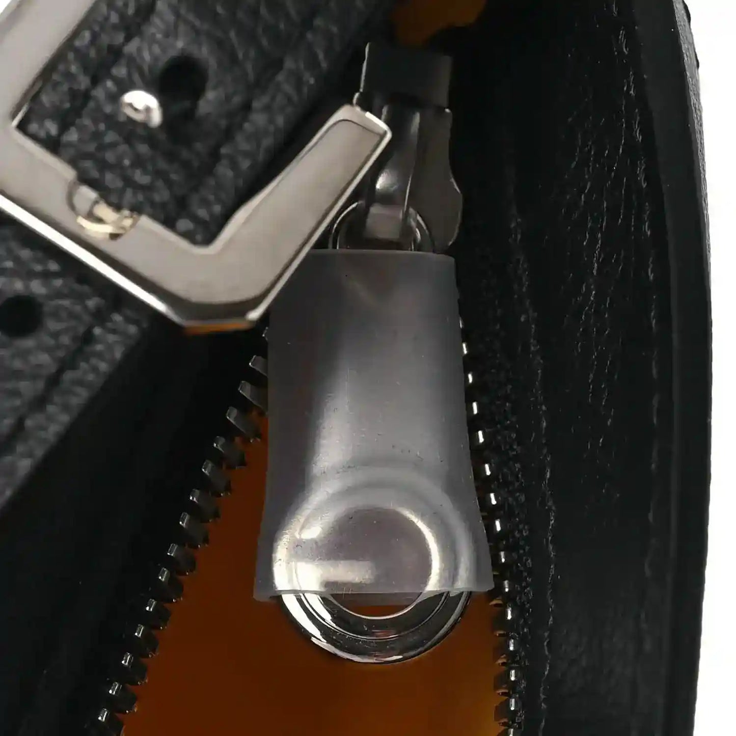 Silver zipper pull over black-lined interior of crossbody handbag