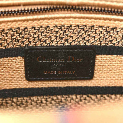 Brand label on jute canvas bag: 'Christian Dior' and 'Made in Italy'.