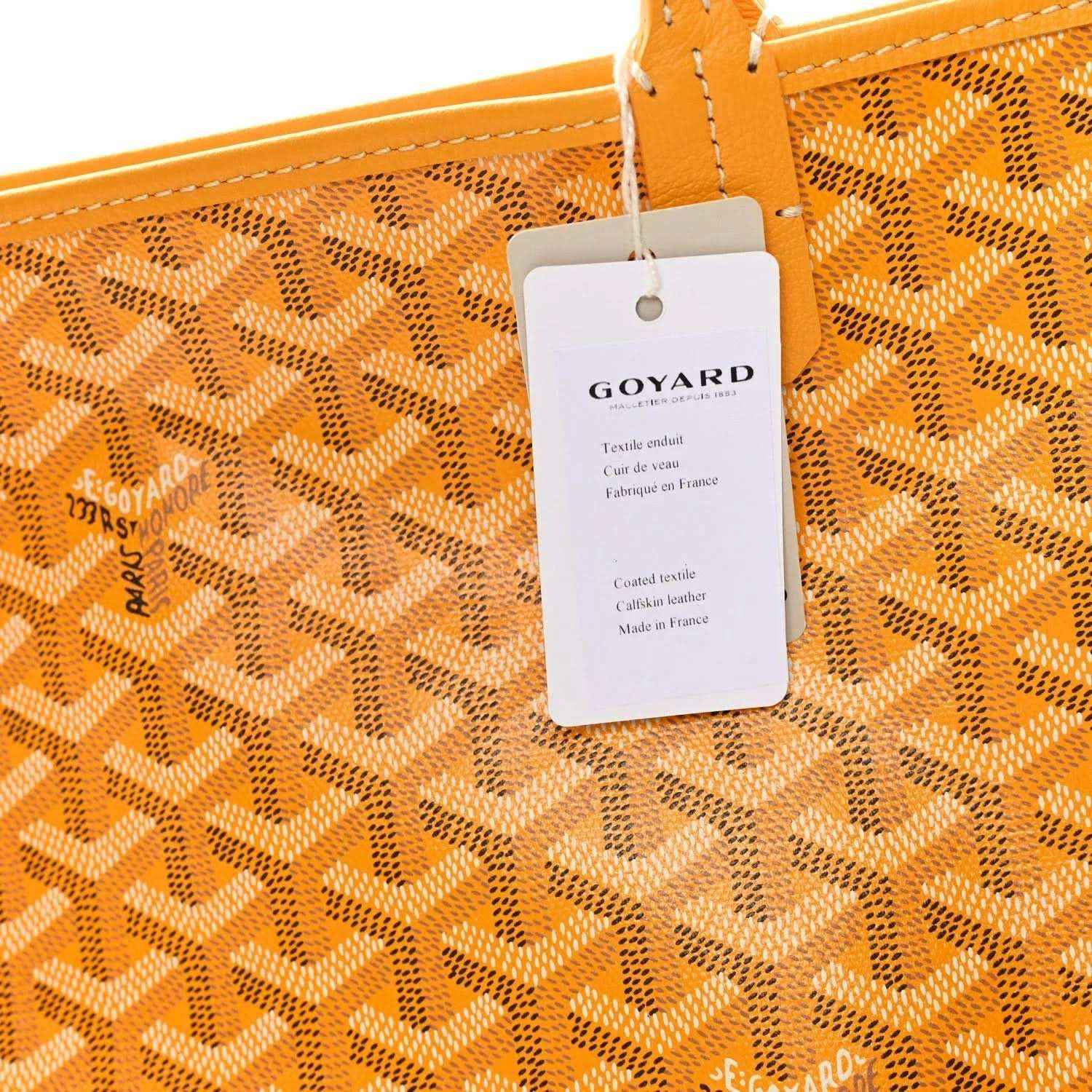 Yellow canvas tote bag with Goyardine pattern and attached GOYARD hang tag