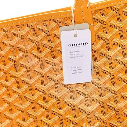 Yellow canvas tote bag with Goyardine pattern and attached GOYARD hang tag
