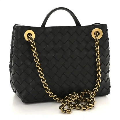 Black woven leather tote bag with gold-tone chain strap and front clasp hardware