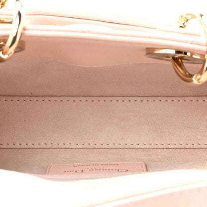 Pink leather handbag interior with stitching and metal hardware on inner wall