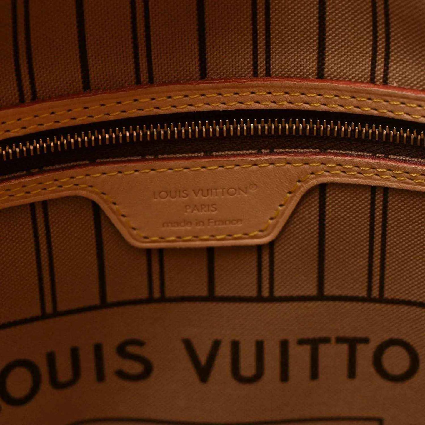 Interior zipper area with Louis Vuitton logo stamp on tan leather patch