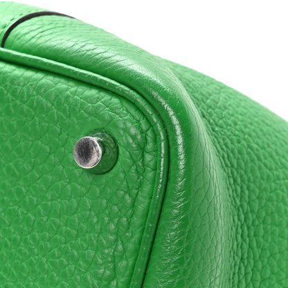 Green leather tote bag close-up of seam edge and round metal turn-lock