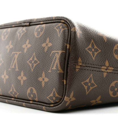 Corner of a dark monogram bag with rounded leather trim and stitched edge seam