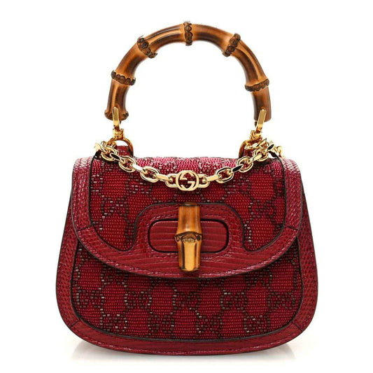 Red mini top-handle bag with bamboo-look handles, gold chain strap, logo front hardware.