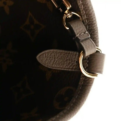 Dark monogram canvas bag with gray leather strap and gold-tone metal ring detail