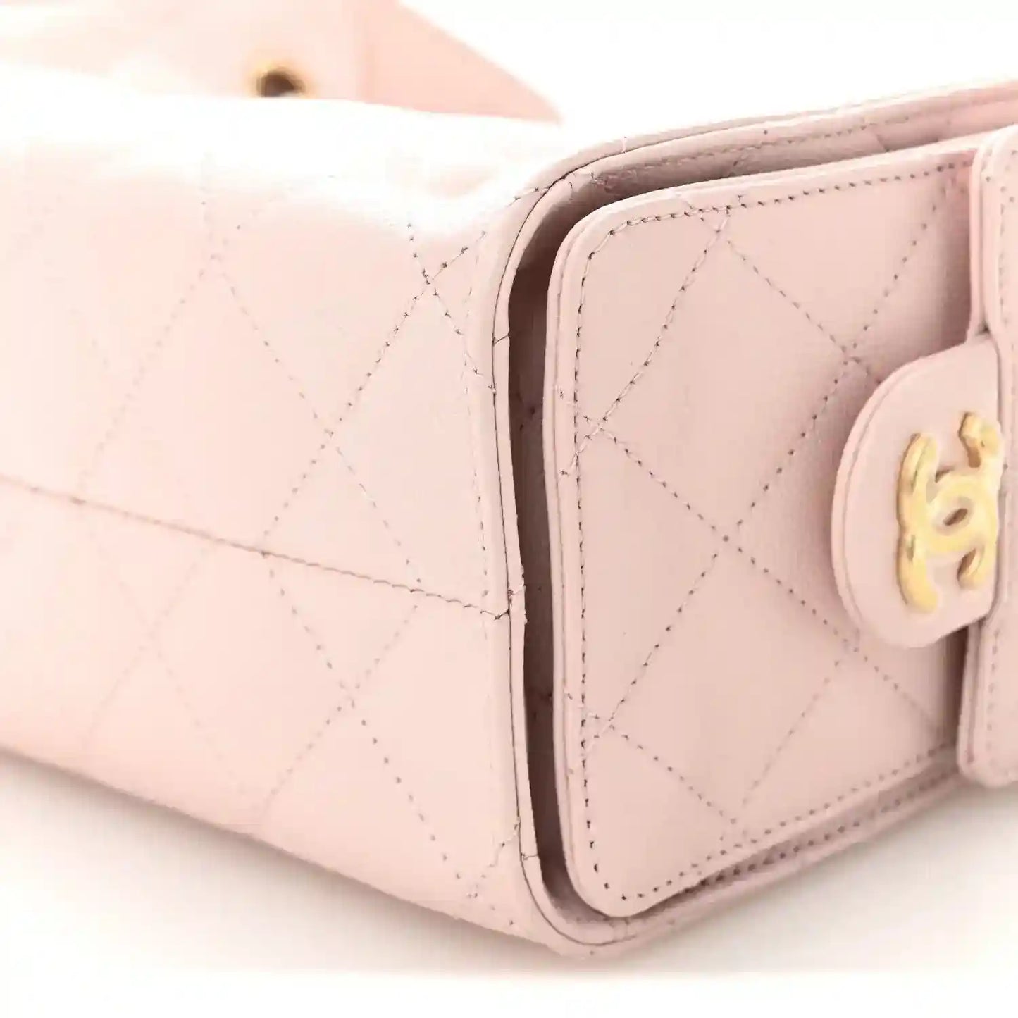 Light pink Chanel mini quilted leather handbag corner close-up with gold turn-lock
