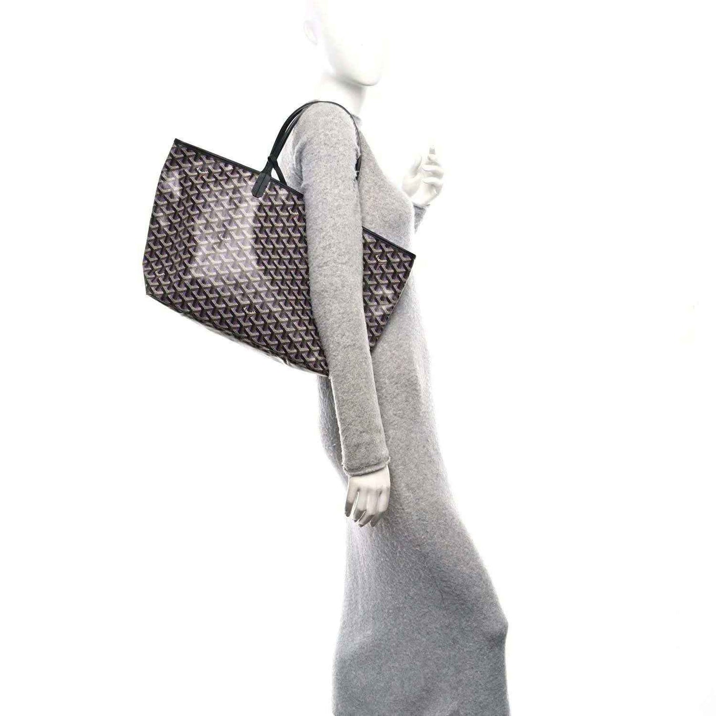 Tote bag on model arm, monogram pattern, black with purple accents; top handles visible