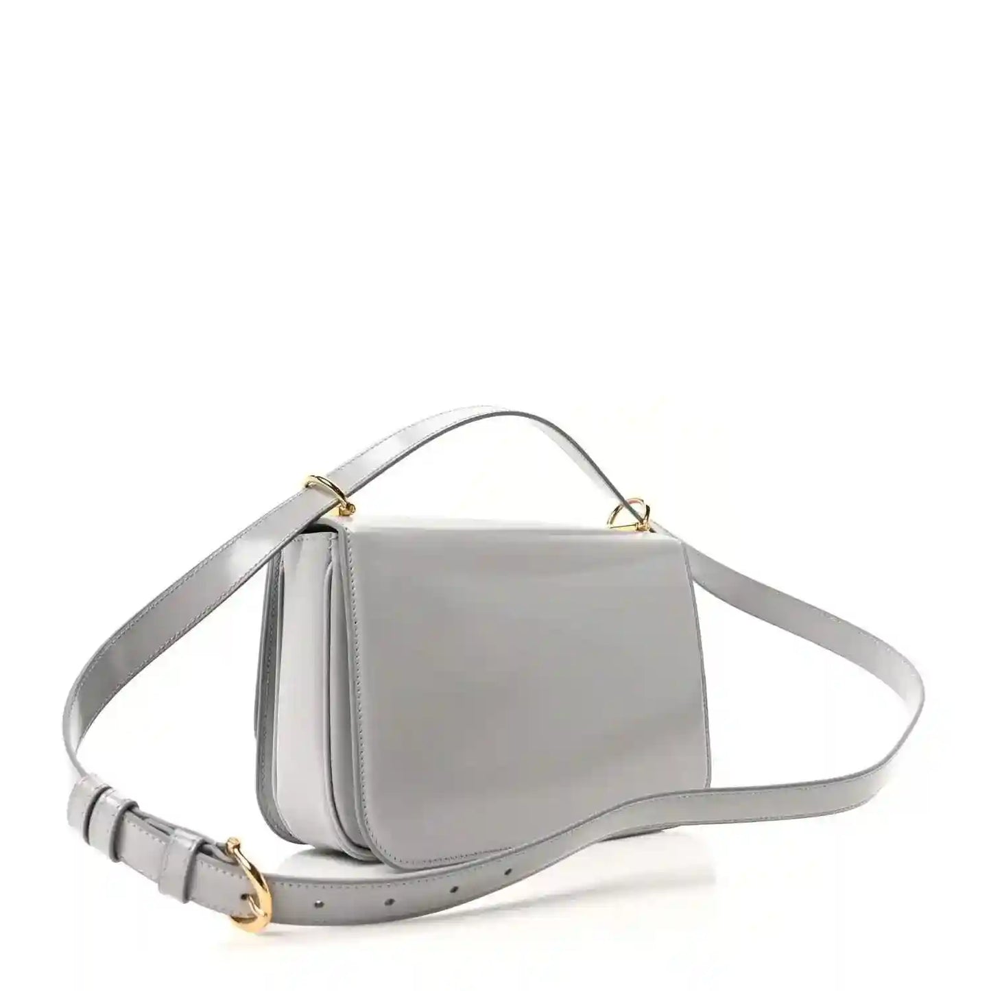 Light grey small shoulder bag with curved flap, gold-tone hardware, and crossbody strap