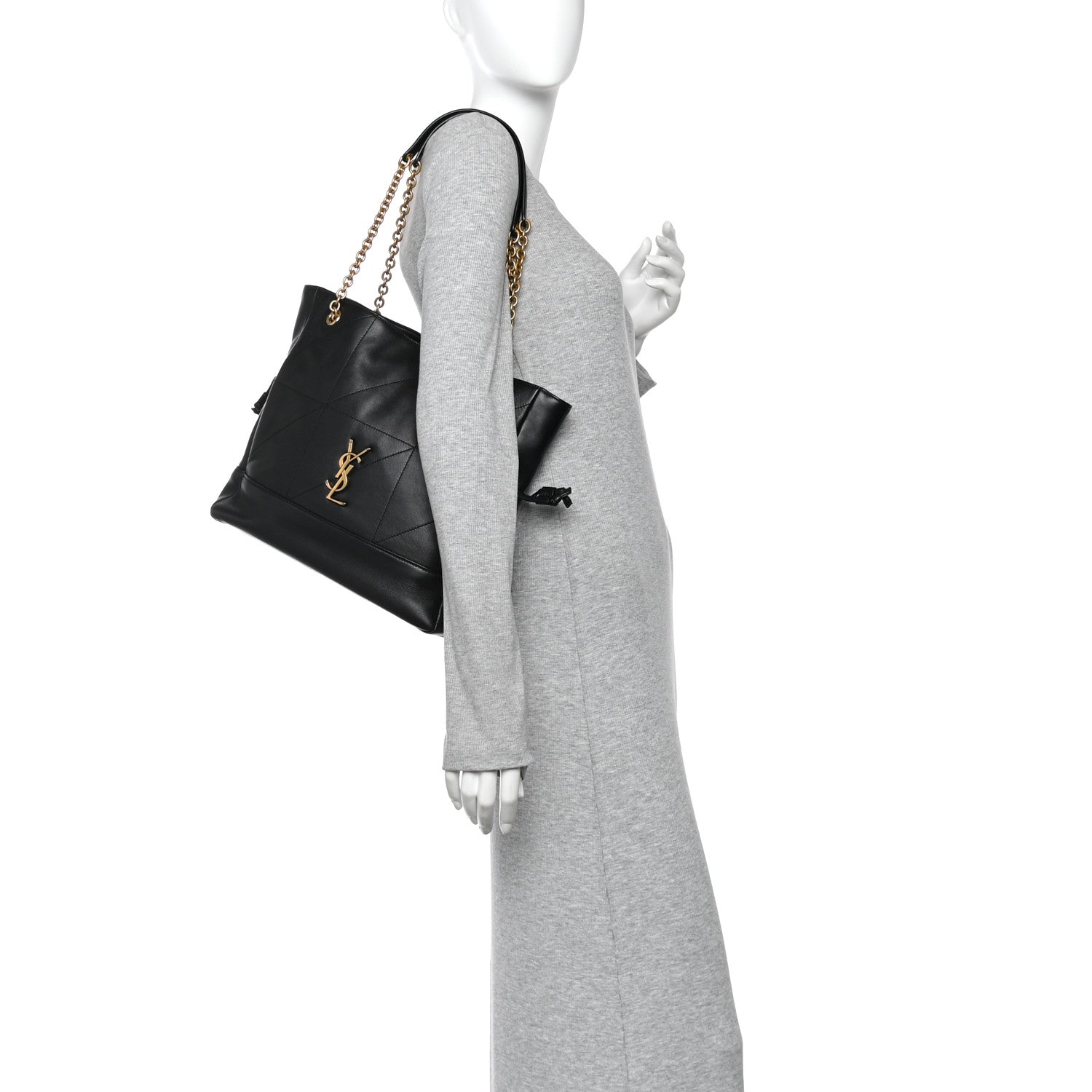 Black small shopping tote on model with gold chain strap and drawstring bow detail.