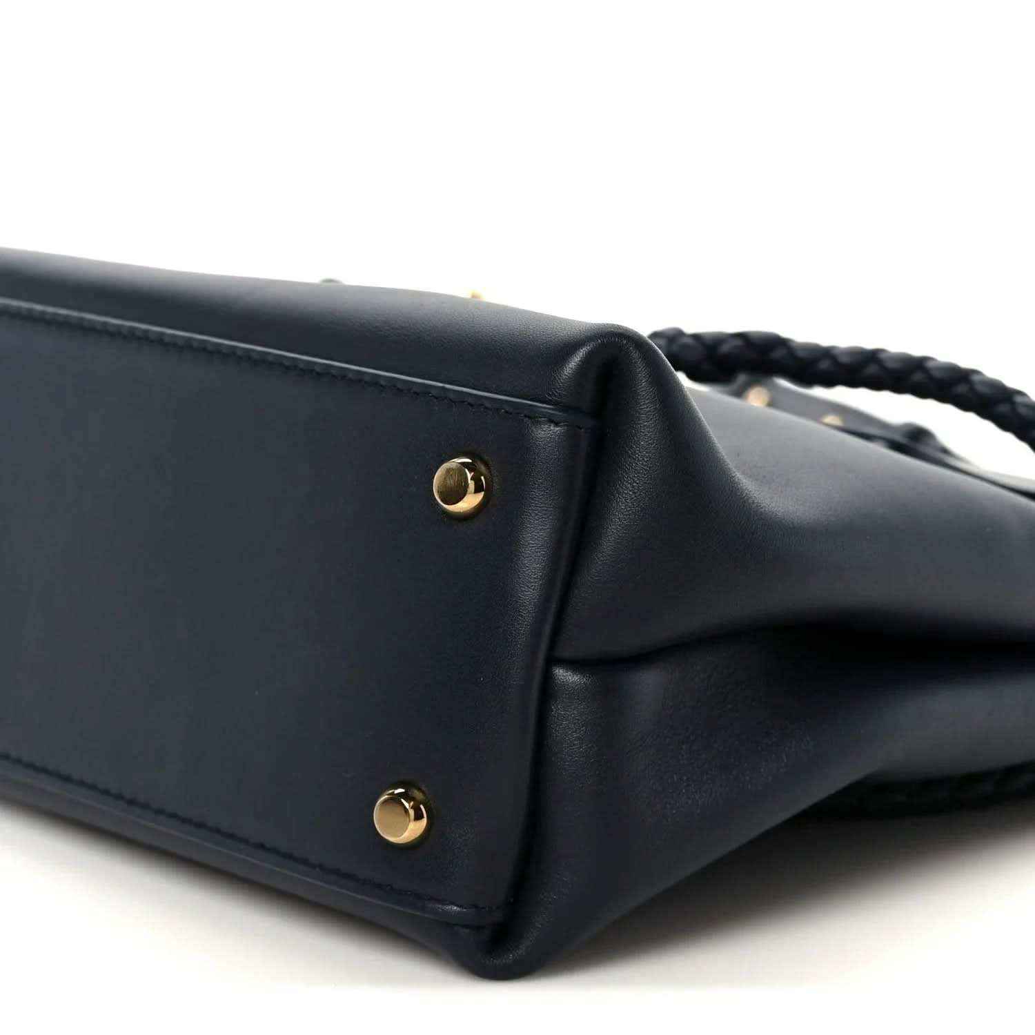 Small black leather handbag corner with gold stud hardware
