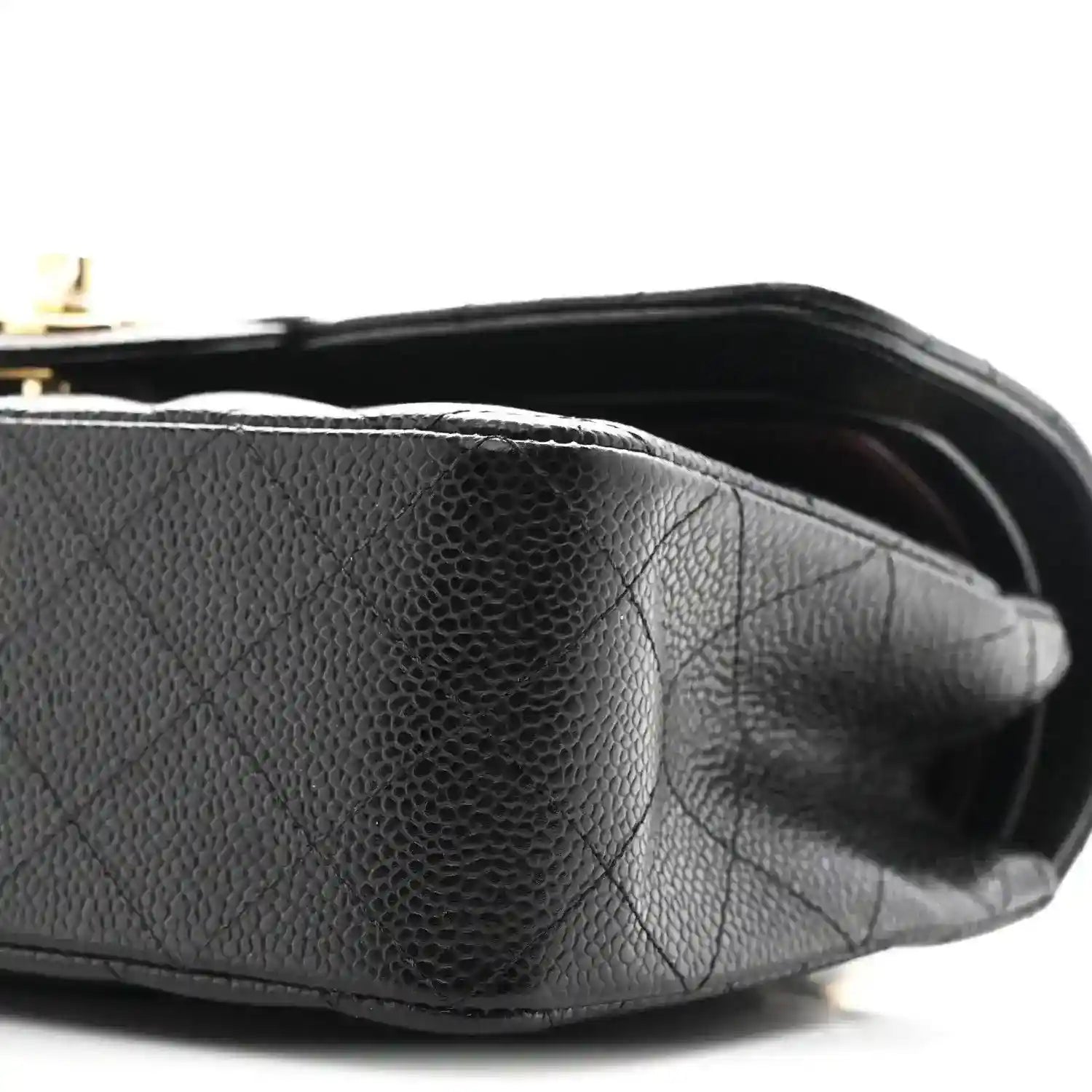 Chanel small double flap bag side view, black pebbled leather with gold hardware details