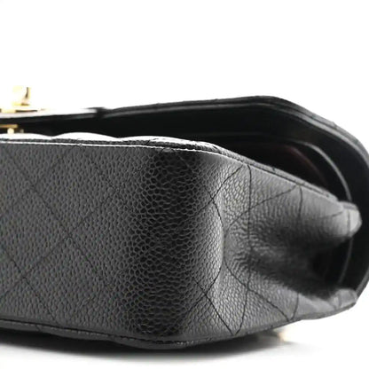 Chanel small double flap bag side view, black pebbled leather with gold hardware details