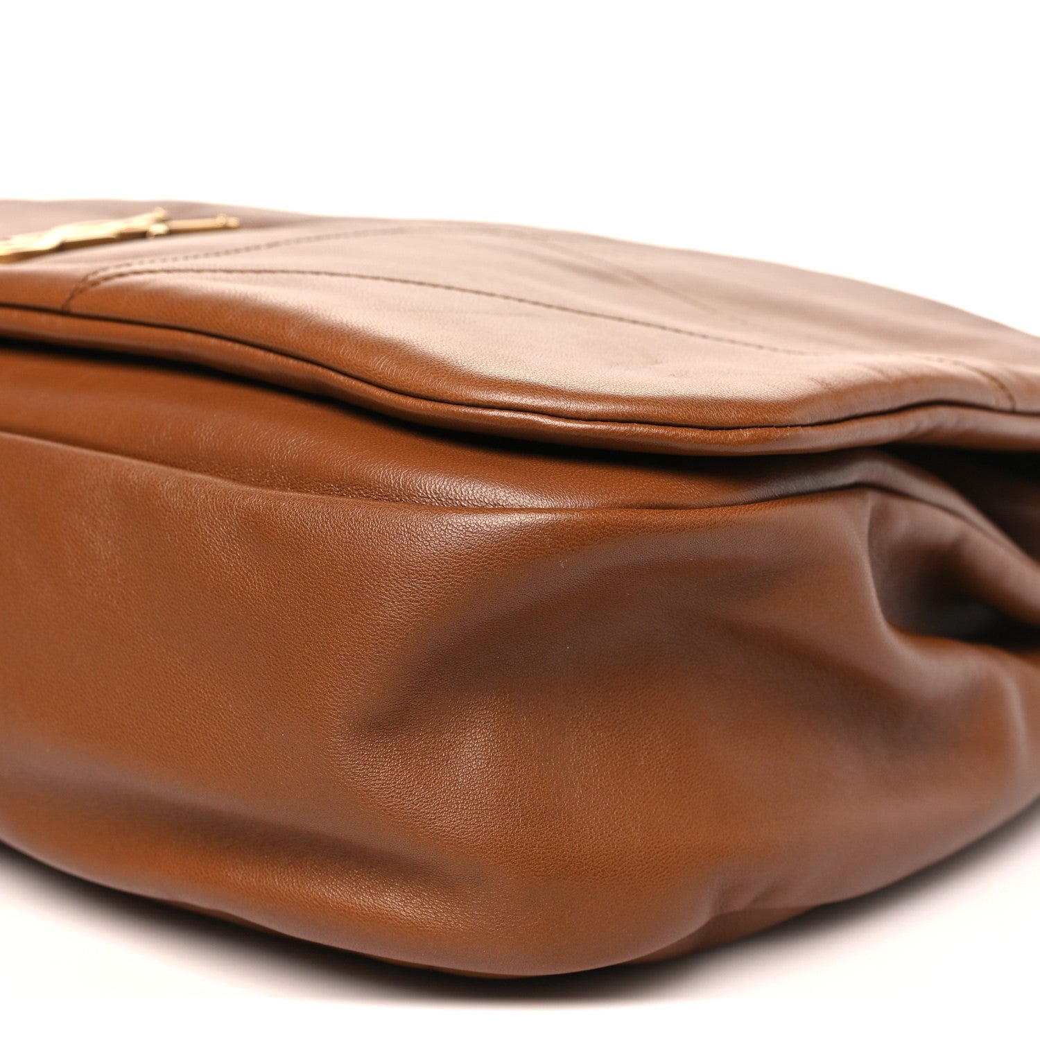 Tan-brown leather bag corner with curved base and stitched edge detail.