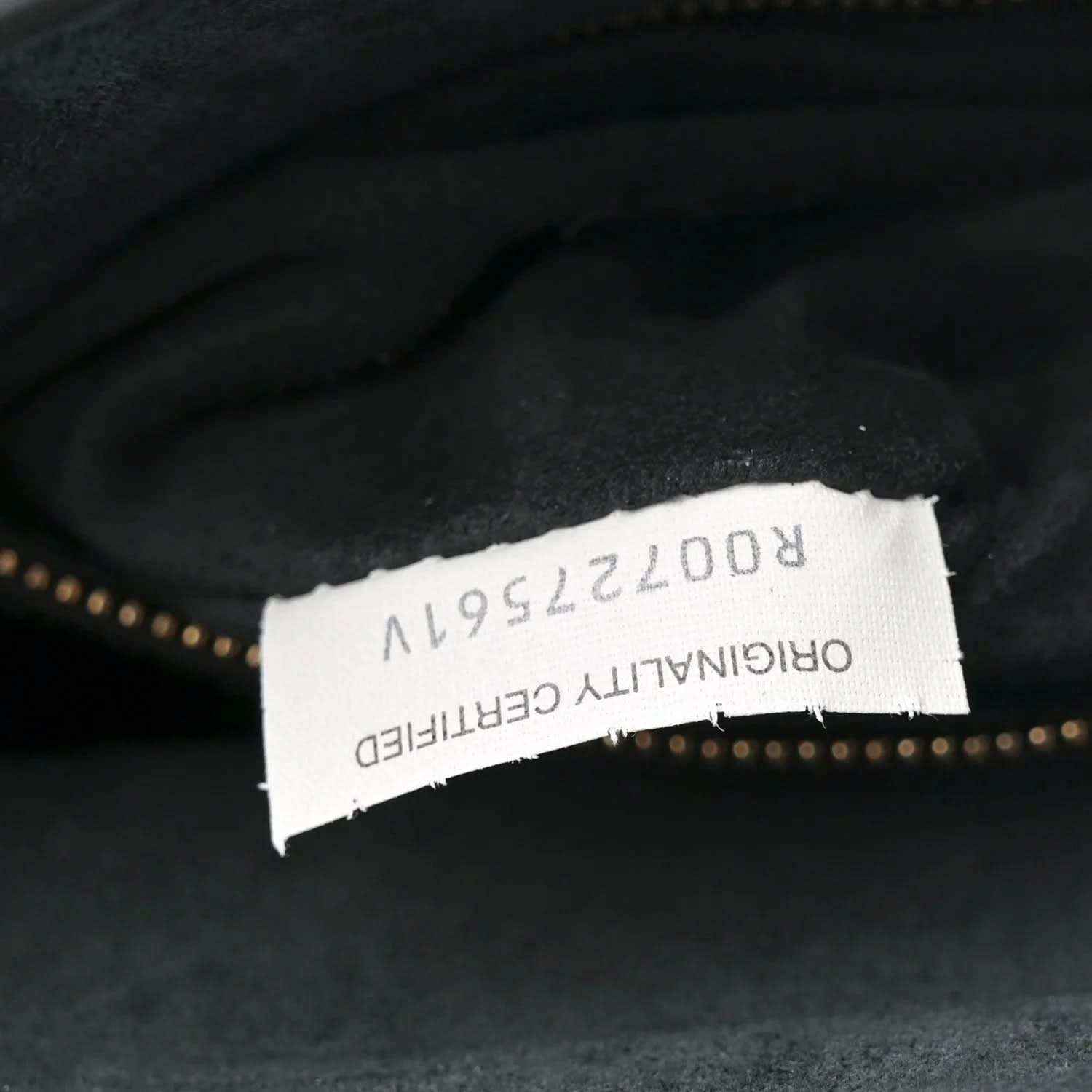 Black leather bag interior with white brand label and model number tag.