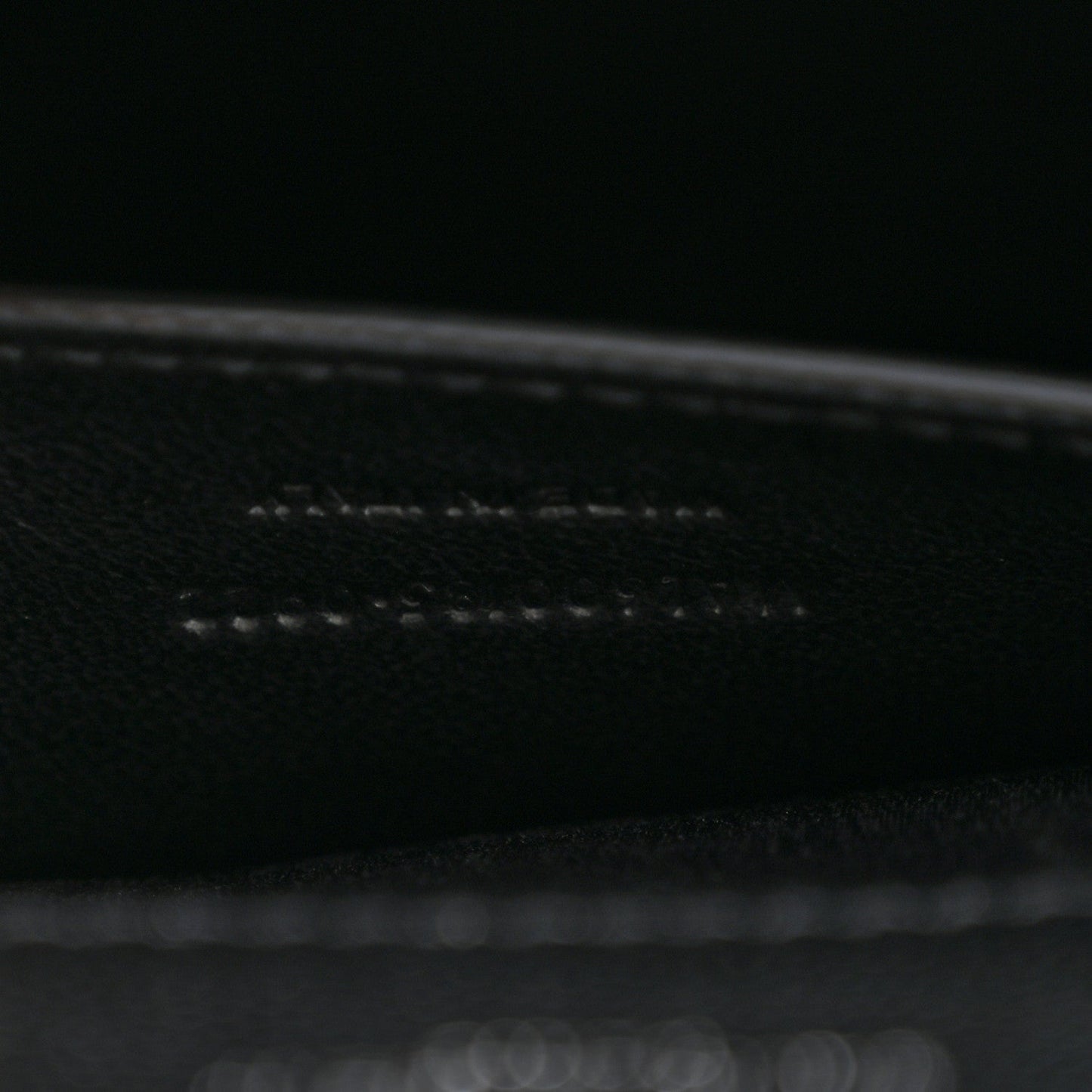 Black leather satchel interior seam and edge stitching close-up