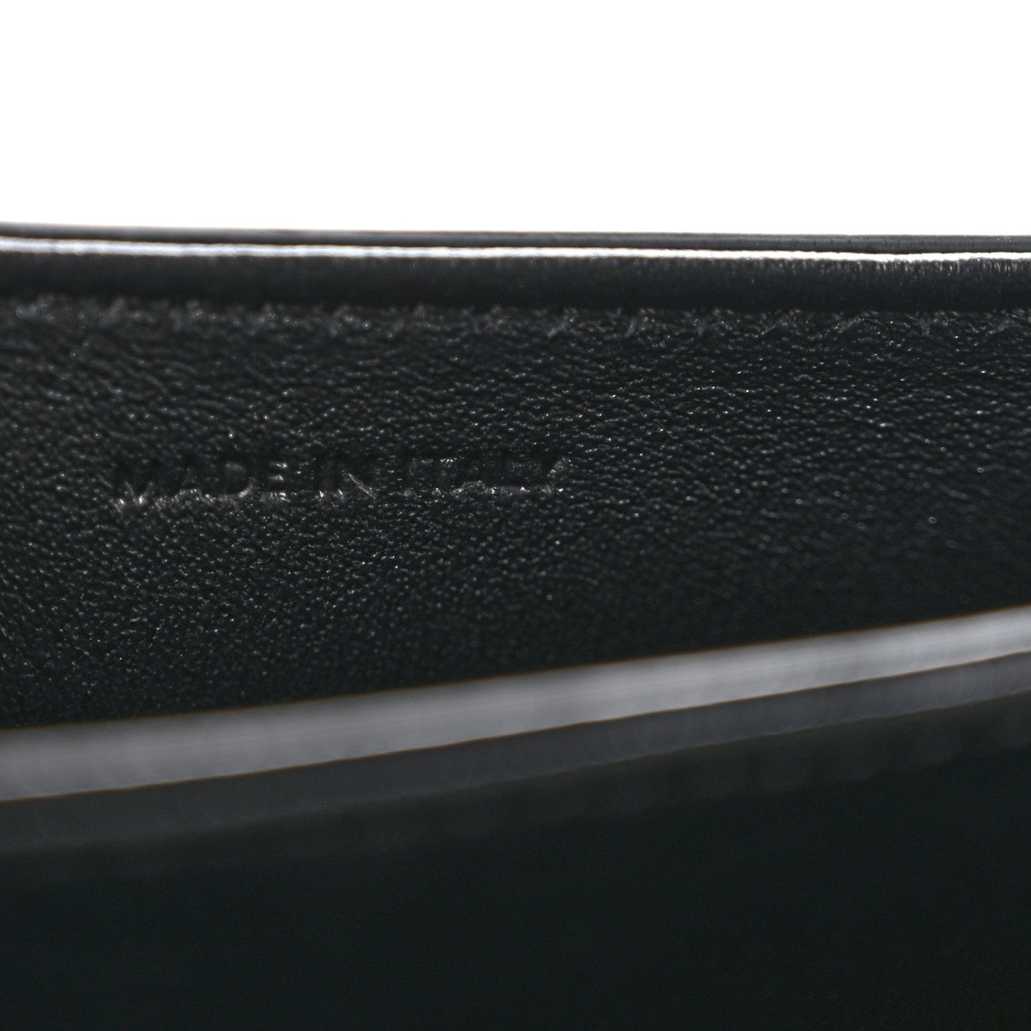 Black leather mini crossbody bag, close-up of interior label text