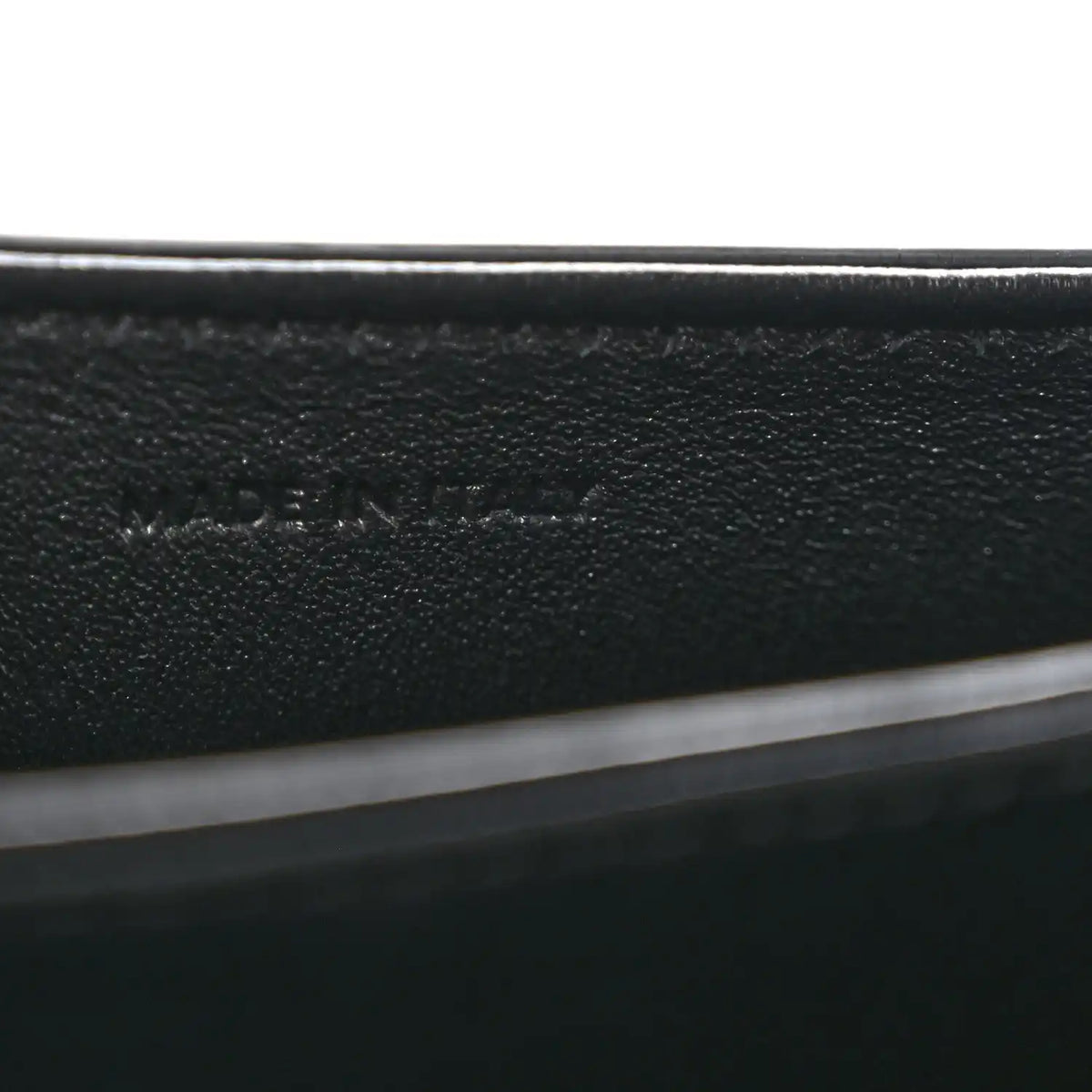 Black leather mini crossbody bag, close-up of interior label text