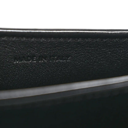 Black leather mini crossbody bag, close-up of interior label text
