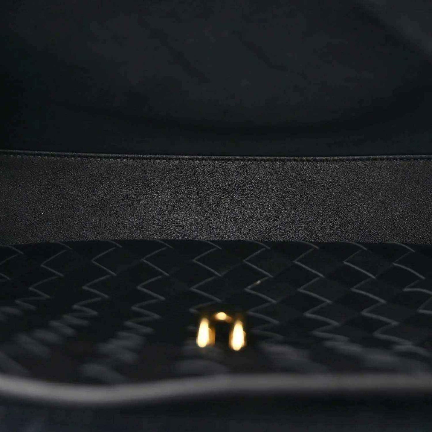 Black leather-lined interior with chevron texture and small gold detail.