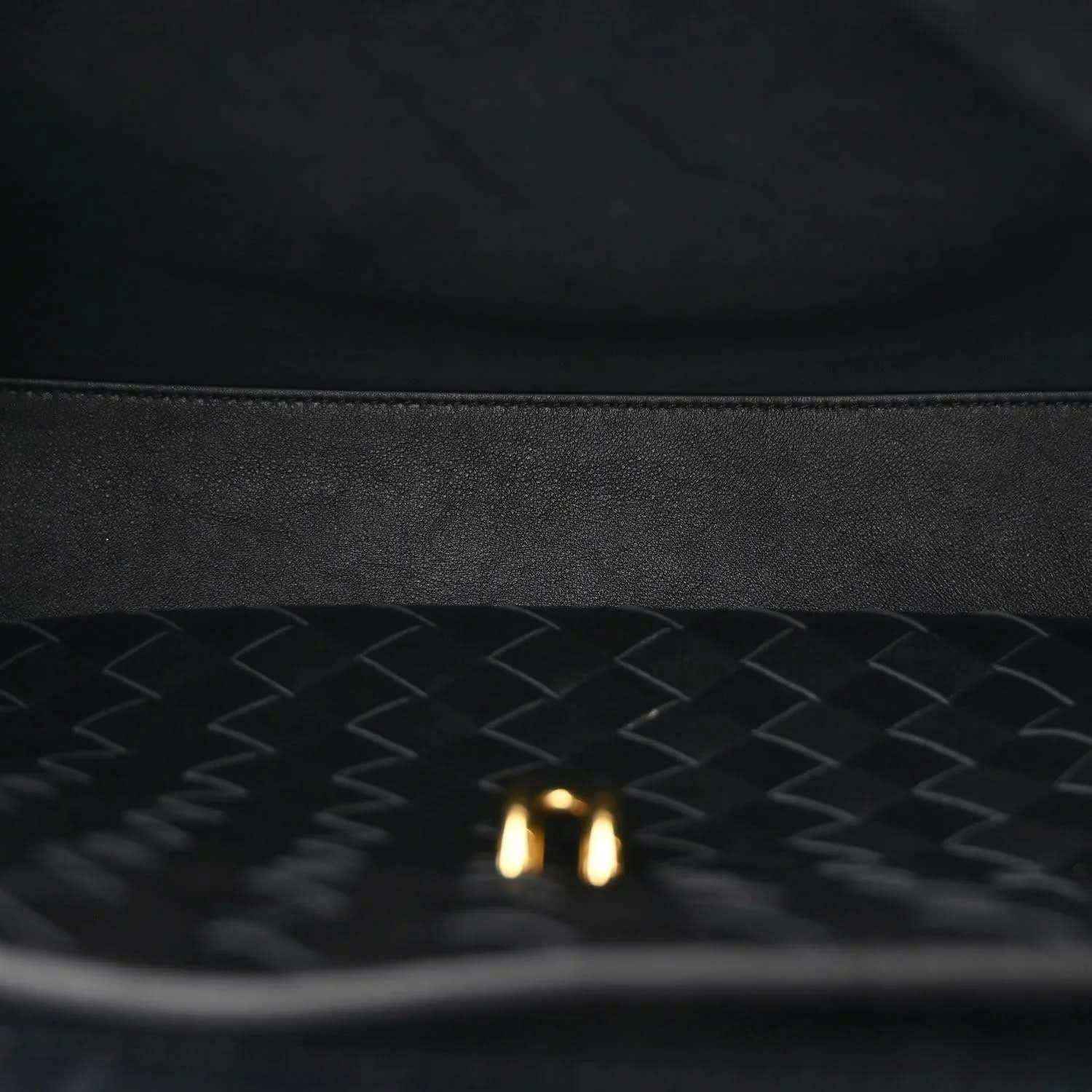 Black leather-lined interior with chevron texture and small gold detail.