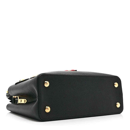 Black Louis Vuitton handbag with top zipper and gold stud hardware on the back