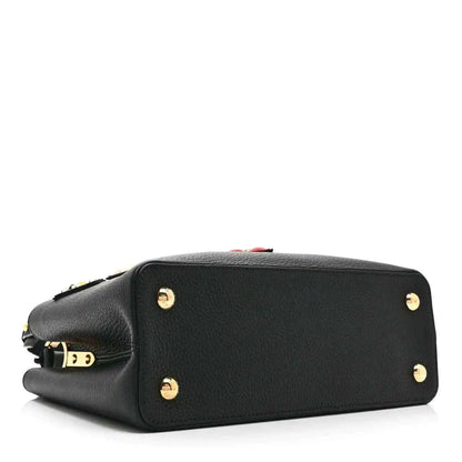 Black Louis Vuitton handbag with top zipper and gold stud hardware on the back