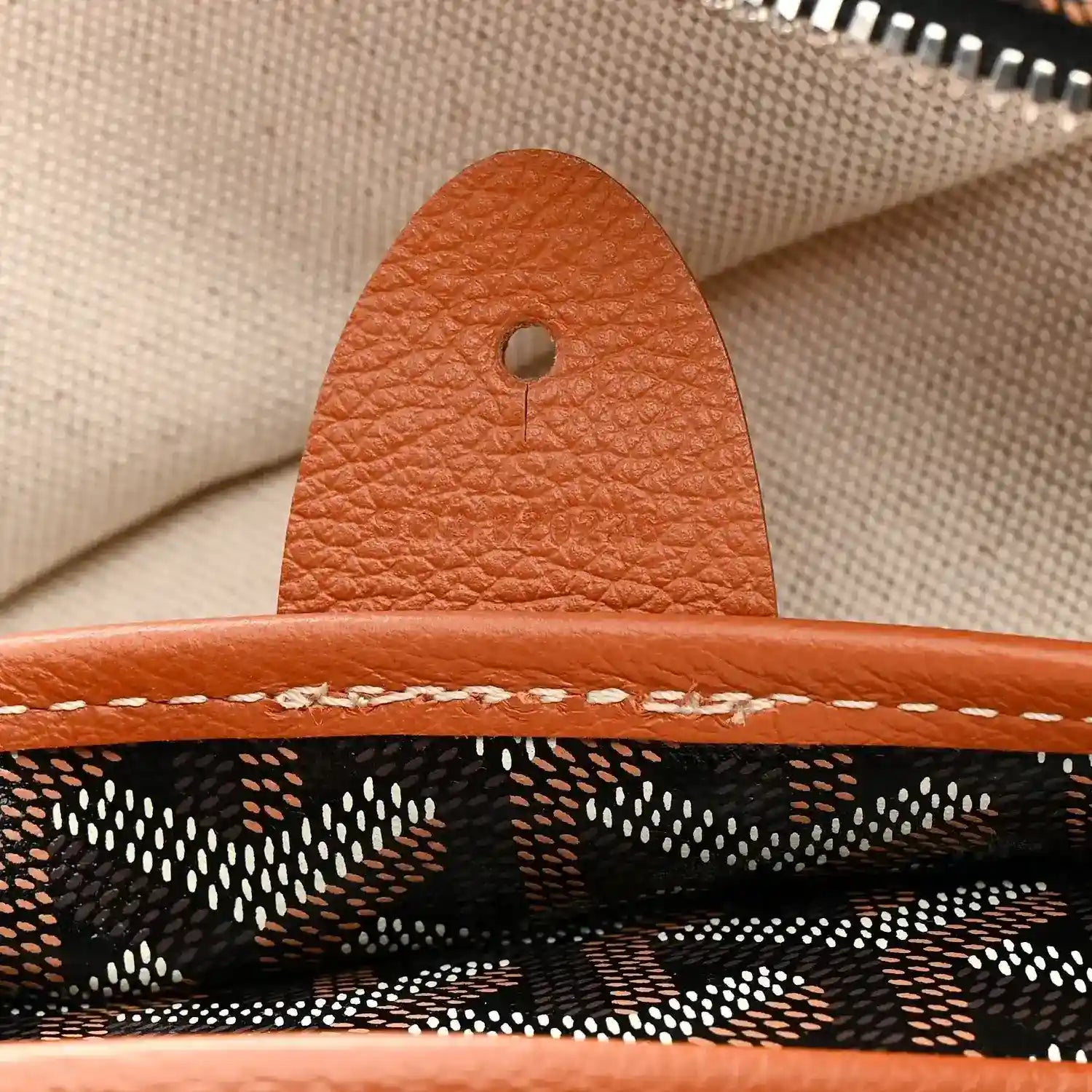 Goyard Artois GM tote bag close-up of tan leather tab and stitching at seam
