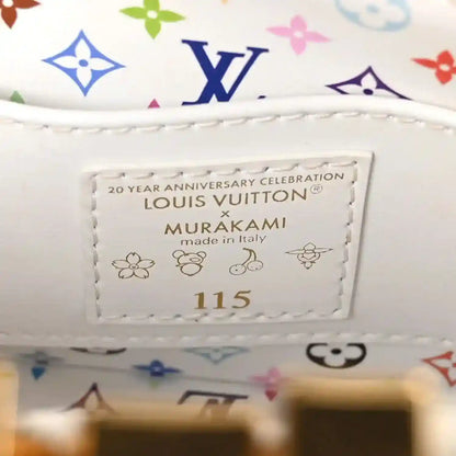White leather luggage tag with text and multicolor monogram trim on the handbag