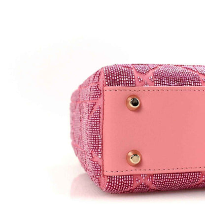 Mini Lady Dior handbag closeup of light pink snap flap with gold button hardware