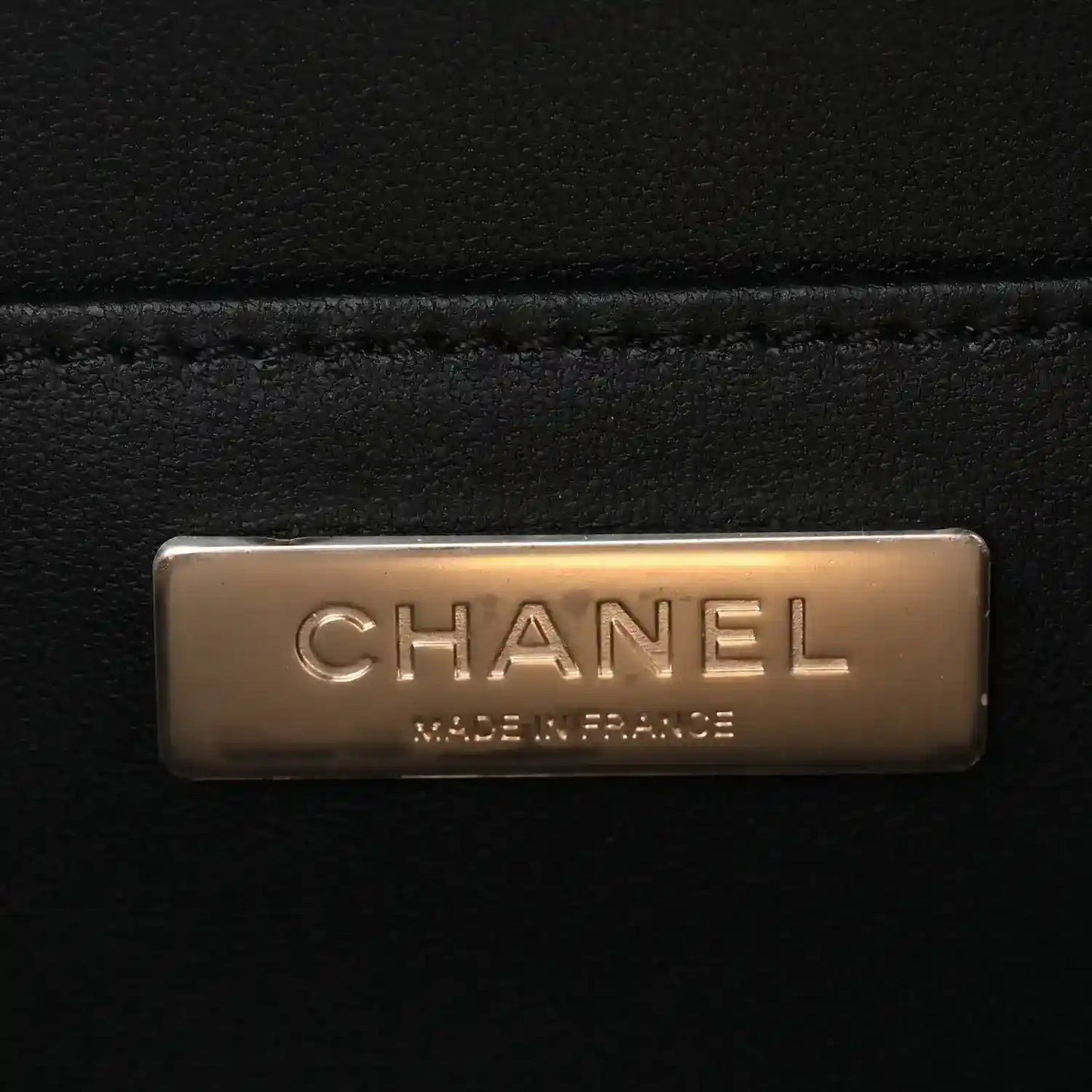 Black leather interior logo plaque reading CHANEL and MADE IN FRANCE