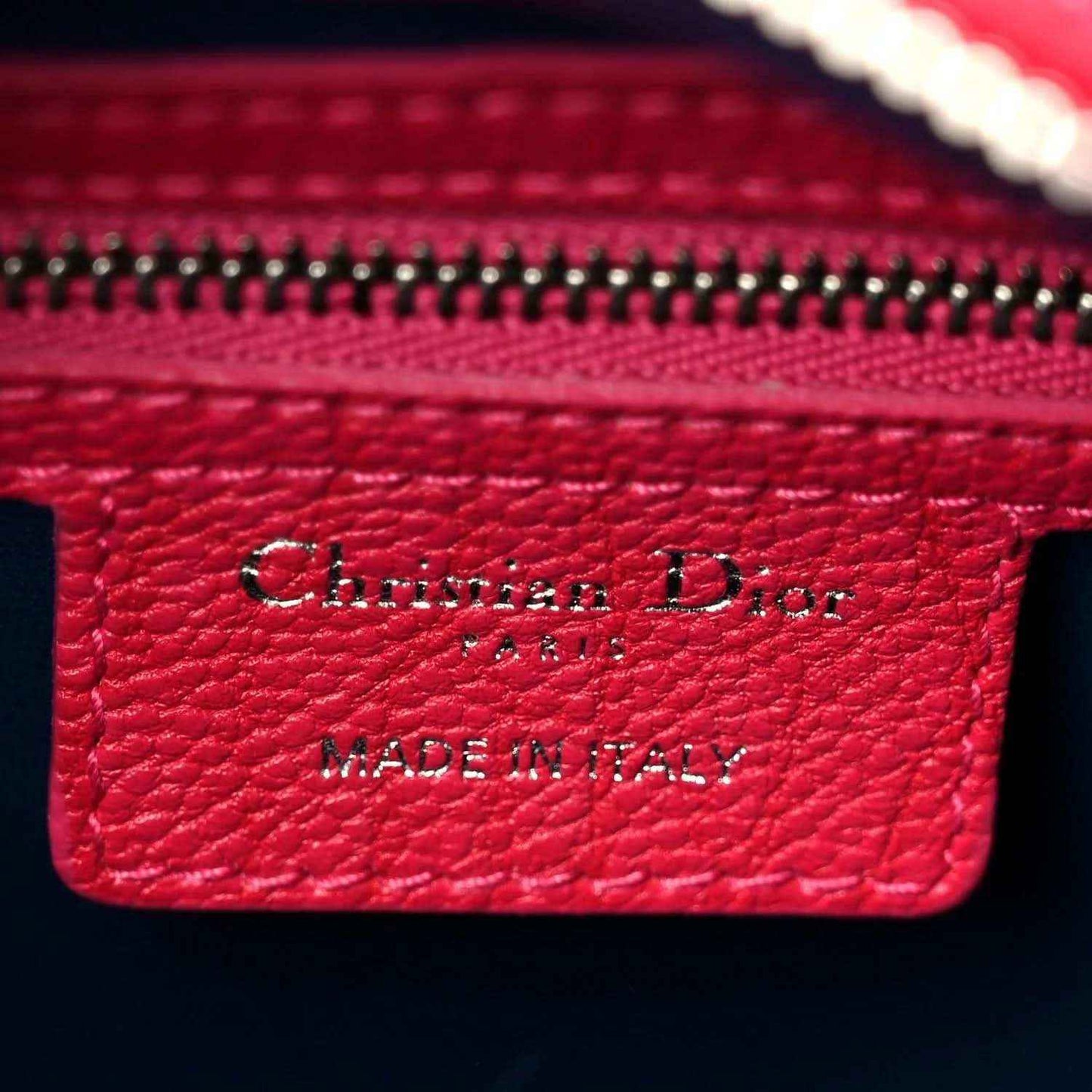 Red leather brand label reading Christian Dior and Made in Italy