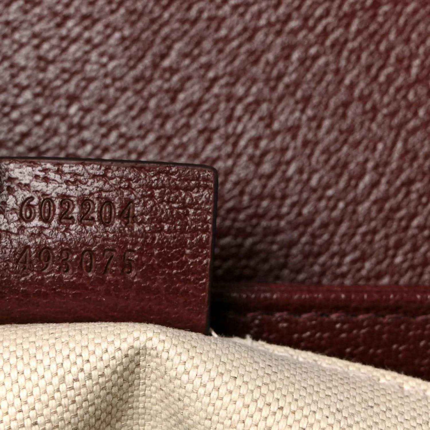 Gucci shoulder bag close-up of interior serial/date code on burgundy leather