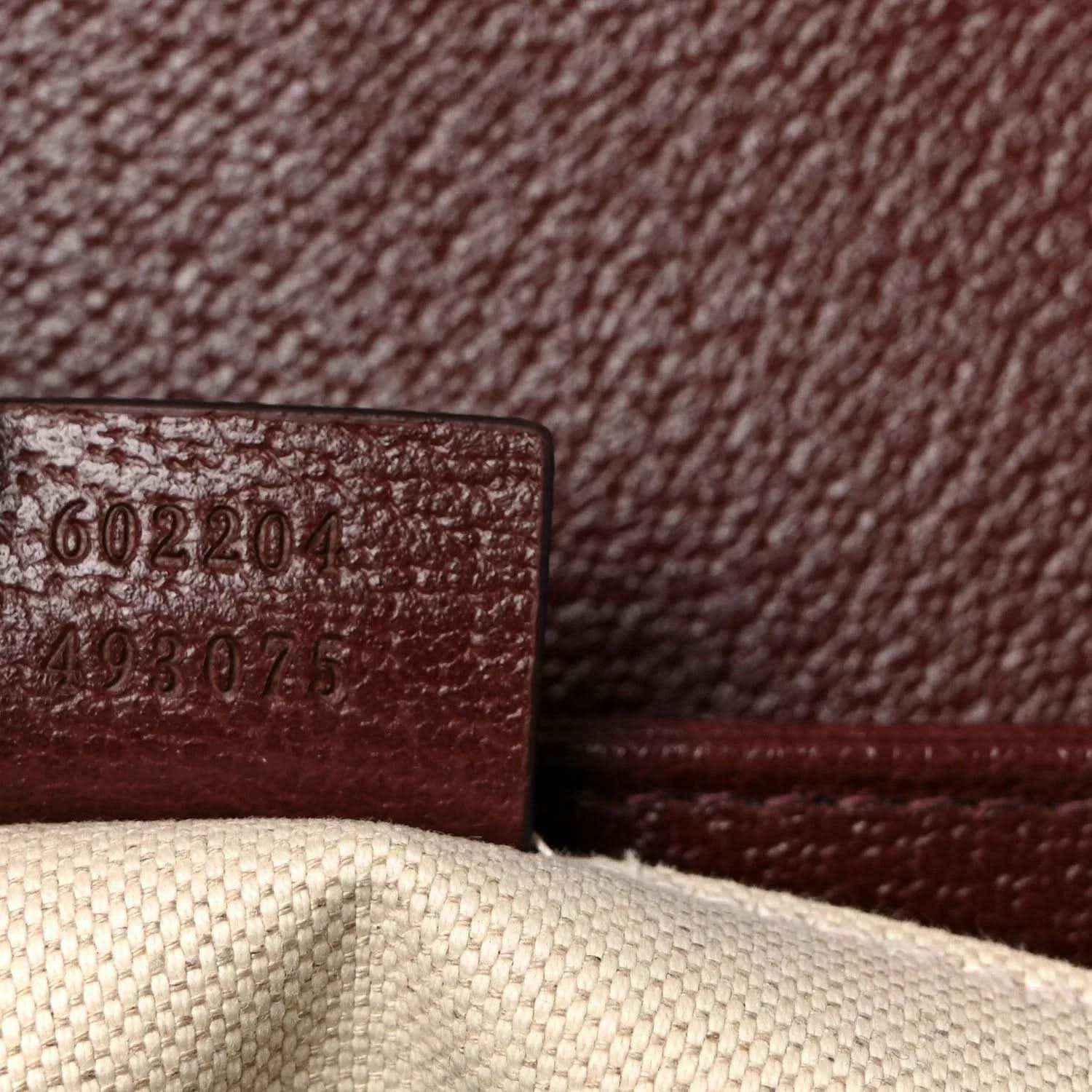 Gucci shoulder bag close-up of interior serial/date code on burgundy leather
