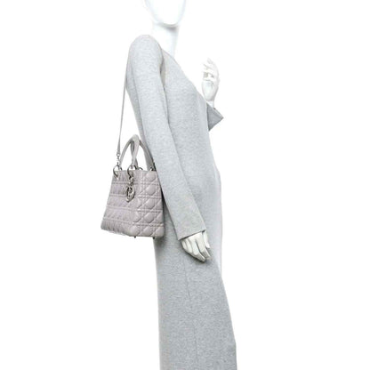 Grey Lady Dior medium handbag worn crossbody with thin shoulder strap and top handles