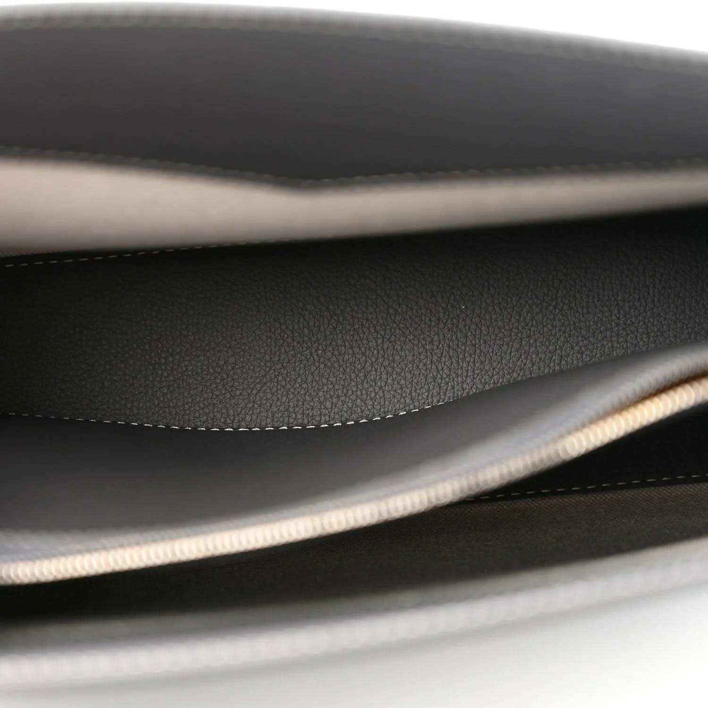 Black interior lining with stitched seam and braided trim along the edge