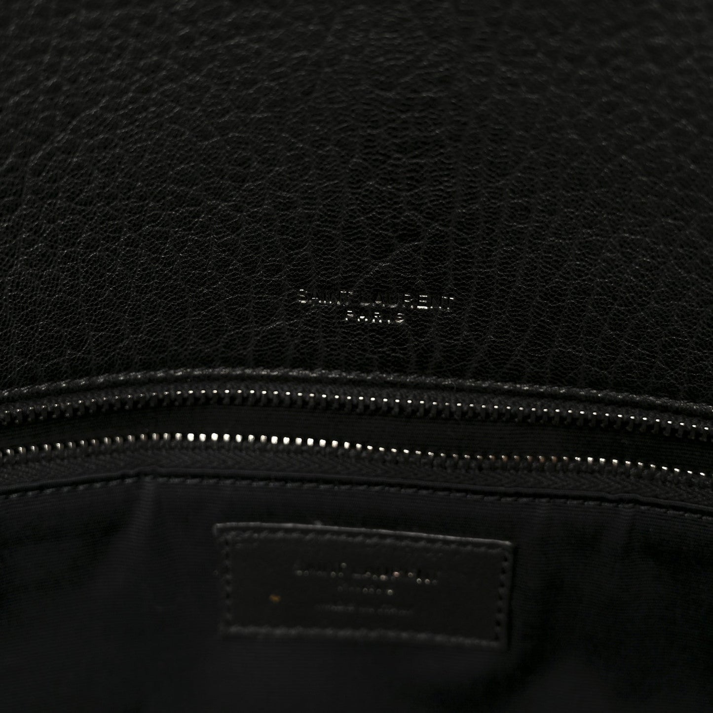 Black leather satchel interior logo patch and stitched zipper top