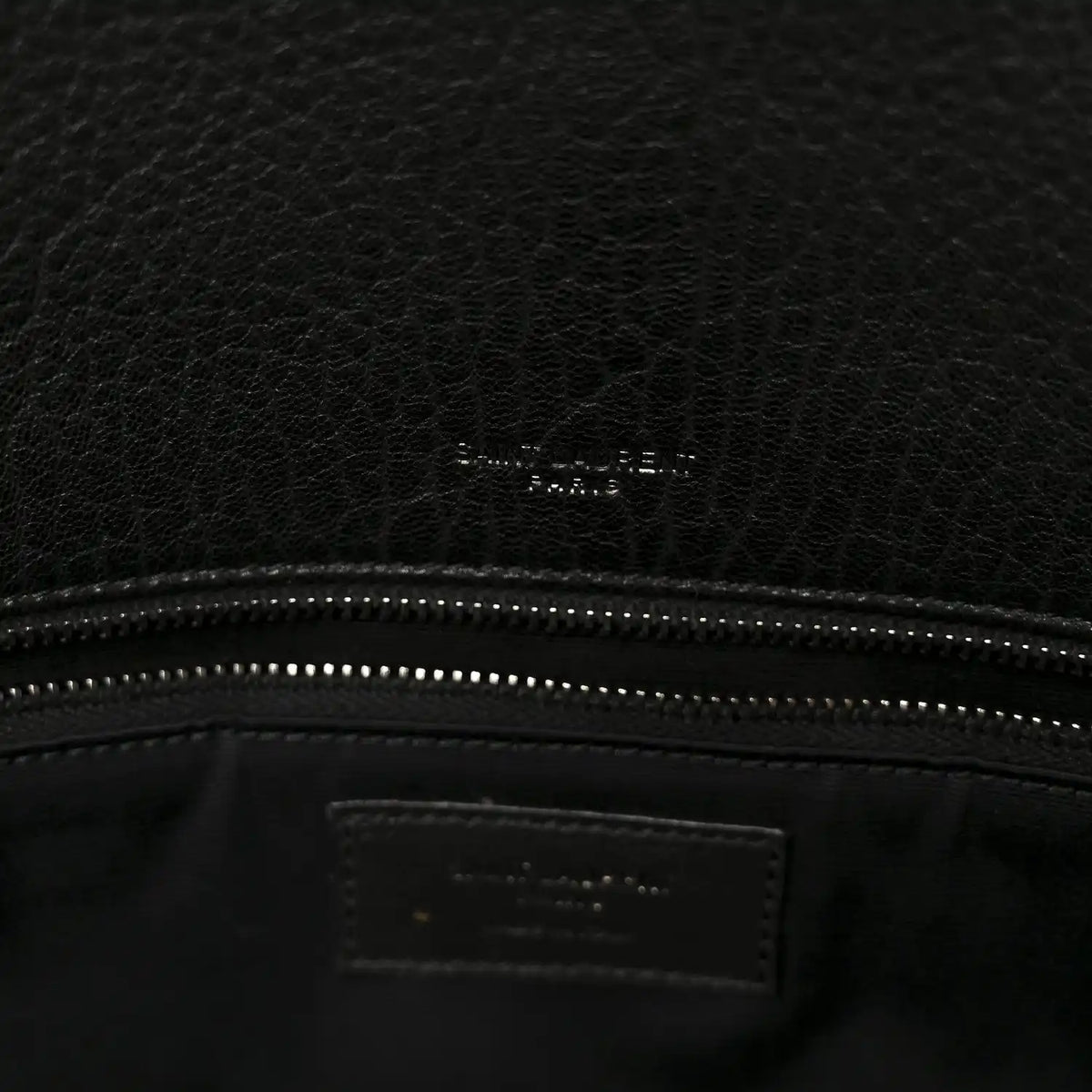 Black leather satchel interior logo patch and stitched zipper top